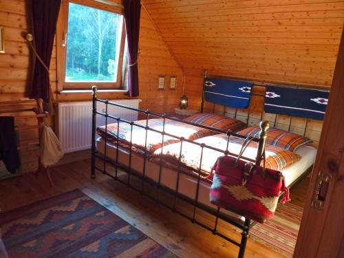 a bedroom with a bed in a wooden cabin at Wild West Lodge 48 Western-Feeling im Harz in Hasselfelde