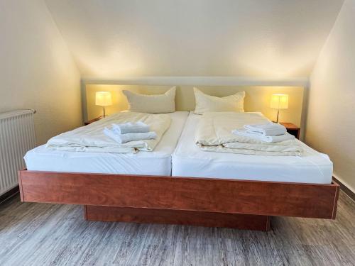 a bedroom with two beds with white sheets and two lamps at Holiday Home Müritz Ferienpark Röbel-62 by Interhome in Röbel