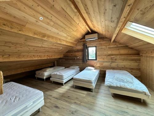 a room with three beds in a log cabin at La Chênaie - Vue imprenable, pêche & grands événements in Roye