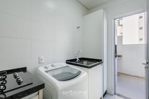 a white kitchen with a sink and a stove at Apt c/ Churrasq. a 600m da Praia GEN0102 in Balneário Camboriú