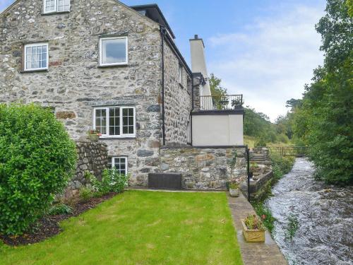 an exterior view of a stone house with a yard at Tryfan - Uk6628 in Pen-y-groes