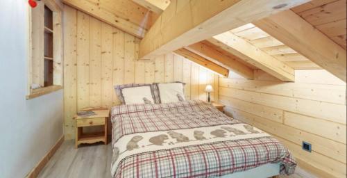 a bedroom with a bed in a log cabin at Gite Les Tarines 2 in Beaufort