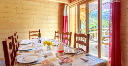 a dining room with a table with plates and flowers at Gite Les Tarines 2 in Beaufort