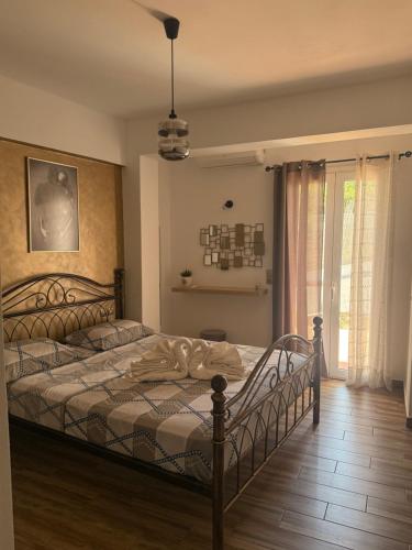 sypialnia z łóżkiem i oknem w obiekcie panorama apartment w mieście Agia Fotia