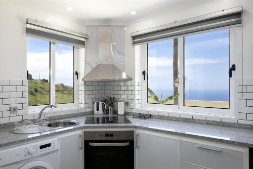 a kitchen with a sink and two windows at Franco's House II, Mar e Serra in Estreito da Calheta