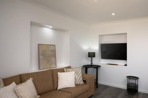 a living room with a couch and a flat screen tv at Franco's House II, Mar e Serra in Estreito da Calheta