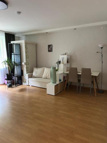 a living room with a white couch and a table at Charming Stay Near Preiļi in Preiļi