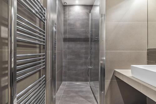 une douche avec une porte vitrée dans une salle de bain dans l'établissement Show Time, à Paris