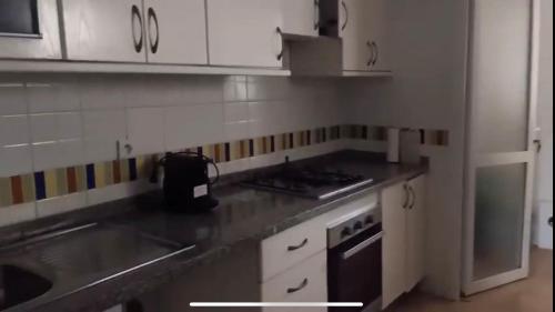a kitchen with white cabinets and a counter top at Appartement Charmant et familiale in Saidia 