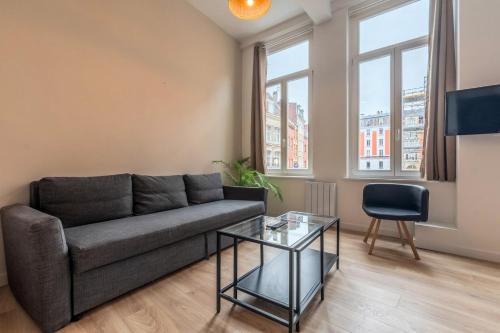 un salon avec un canapé et une table en verre dans l'établissement Lille Gares - 50m2 apartment!, à Lille
