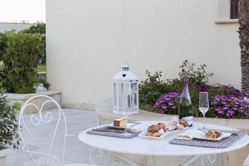 a table with a plate of food and wine glasses at Palascìa Wellness Relais in Otranto