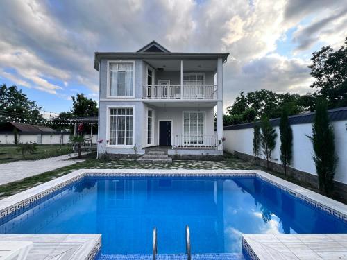 a house with a swimming pool in front of a house at VIP Family Villa HOT POOL in Gabala