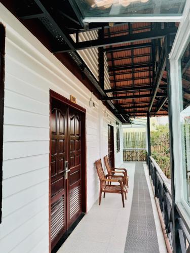 a porch with two chairs and a wooden door at Activate C3 Hostel in Phnom Penh