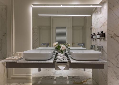 a bathroom with two sinks and a large mirror at LUBICH Concept Hotel in Lviv