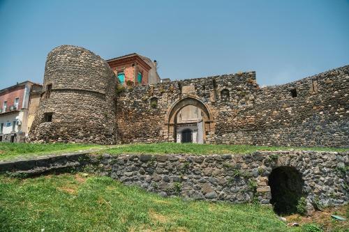an old stone building with a stone wall at Ai piedi della collina in Melfi