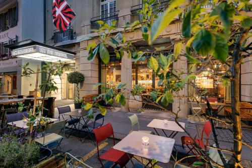 a restaurant with tables and chairs in front of a building at NH Bern The Bristol in Bern