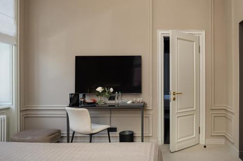 a bedroom with a table with a television and a chair at LUBICH Concept Hotel in Lviv
