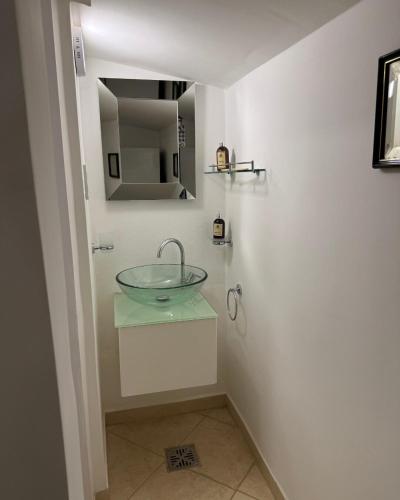 a bathroom with a glass sink and a mirror at Don Antonio Apart 3 in Resistencia