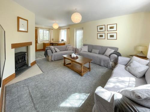 a living room with two couches and a table at Cornant in Llechryd