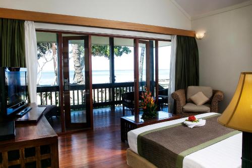 a hotel room with a bed and a balcony at The Naviti Resort in Korolevu