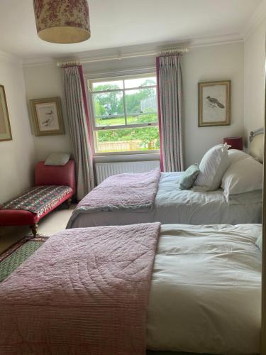 a bedroom with two beds and a window at Oak Lodge in Moreton Pinkney