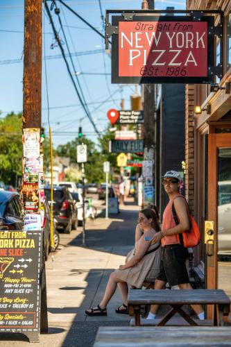 two women sitting on a bench on a city street at Stay Portland - Perfect Portland Farmhouse Loft - Breweries & Bars in Portland