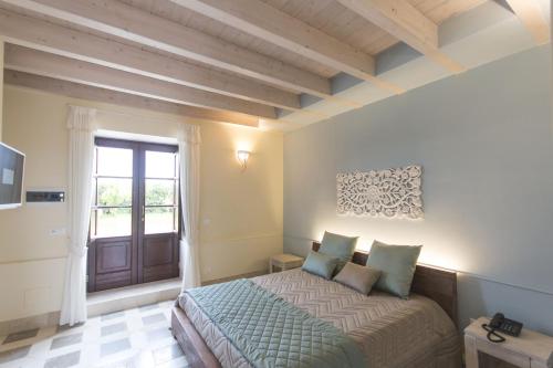 a bedroom with a large bed and a window at Palascìa Wellness Relais in Otranto