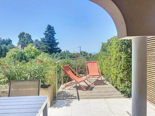 deux chaises oranges assises sur un porche avec vue dans l'établissement 5-room studio - sea view- terrace - parking, à Saint-Raphaël