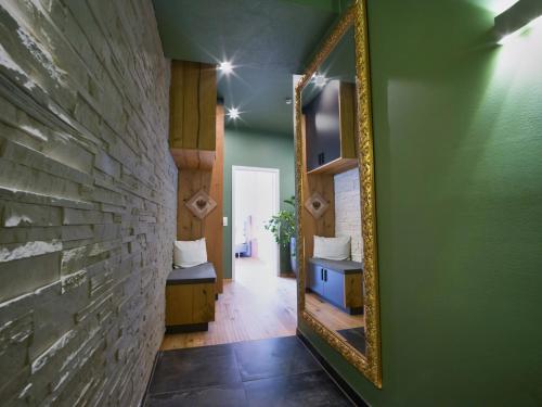 a mirror on a green wall in a hallway at COLORGRAM Loft - Colorful Design Apartment in Tyrol, presented by AlpenLuxus in Kramsach