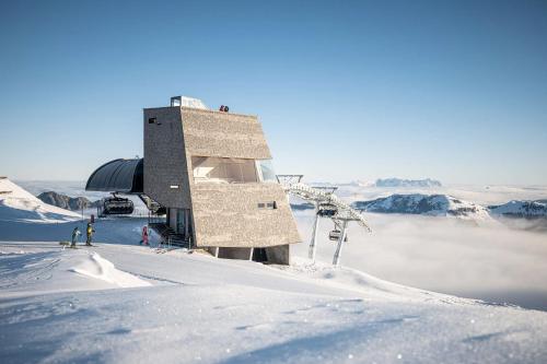 a building on the top of a snow covered mountain at COLORGRAM Loft - Colorful Design Apartment in Tyrol, presented by AlpenLuxus in Kramsach