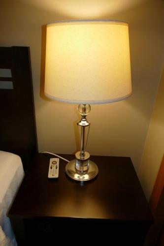 a lamp sitting on a table with a remote control at Ecuabook Torre sol 27 You Home in Guayaquil