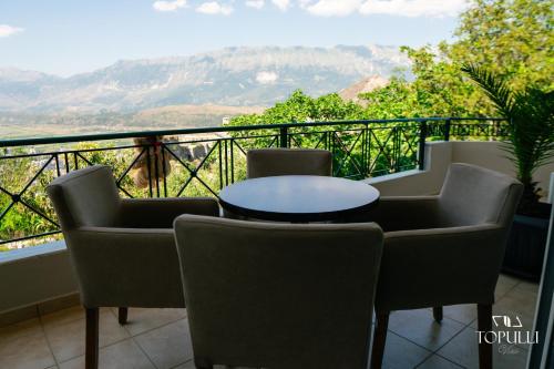 a table and chairs on a balcony with a view at Villa Topulli View in Gjirokastër