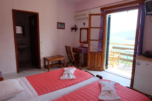 a bedroom with a bed and a large window at Pension Galini in Armenistis