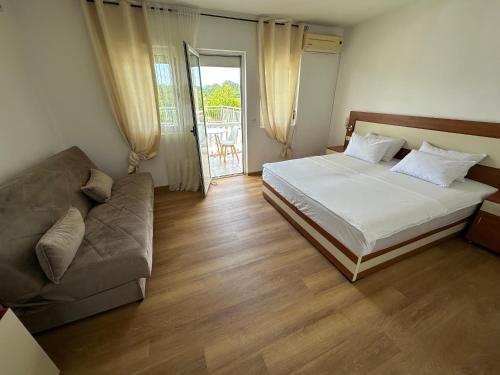 a bedroom with a bed and a couch at Villa Paris in Donji Štoj