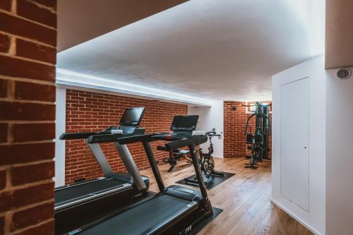 a gym with a brick wall and exercise bikes at Hotel resort Lovecká bašta Strakonice in Strakonice
