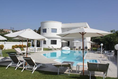 a pool with chairs and umbrellas in front of a house at Al Mare da Francesca in Olbia