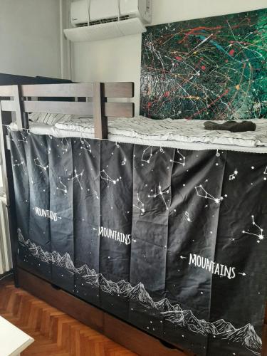 a bed covered in plastic with the names of mountains and moons at Smart hostel in Belgrade