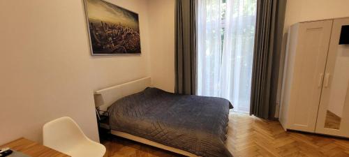 a bedroom with a bed and a large window at Asnyk Prestige Apartments in Kraków
