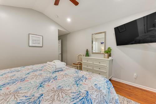 a bedroom with a bed and a dresser and a tv at Bluffton Getaway with Fenced Yard 7 Mi to Beach! in Bluffton