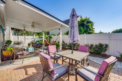 a patio with a table and chairs and an umbrella at Bluffton Getaway with Fenced Yard 7 Mi to Beach! in Bluffton