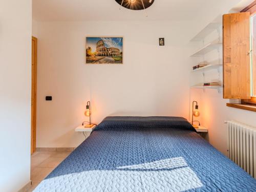 a bedroom with a bed with a blue bedspread at Apartment Buongusto by Interhome in Bugiallo