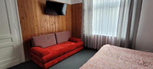 a red couch in a bedroom with a bed at Asnyk Prestige Apartments in Kraków