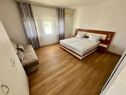 a small bedroom with a bed and a couch at Villa Paris in Donji Štoj