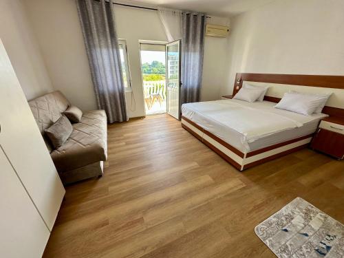 a bedroom with a bed and a couch at Villa Paris in Donji Štoj