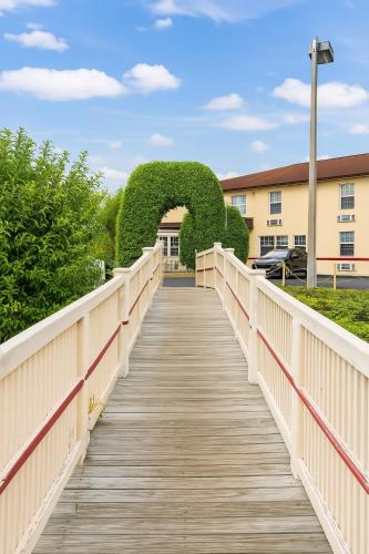 a boardwalk leading to a building with a hedge on it at Belmont Inn & Suites in Florida City