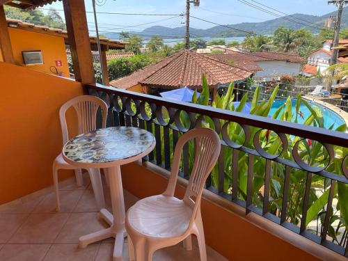 a table and two chairs on a balcony with a view at Pousada Do Forte in Paraty