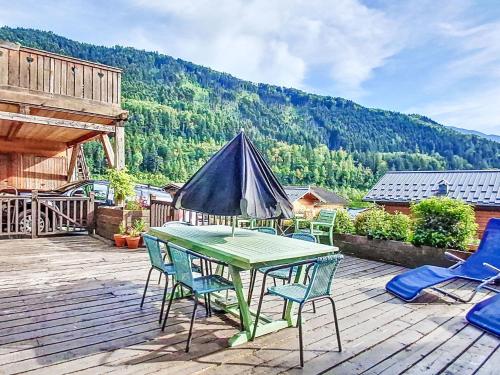 a patio with a table and chairs on a deck at Apartment Bellentre Chalet le Pommier 5 by Interhome in Bellentre