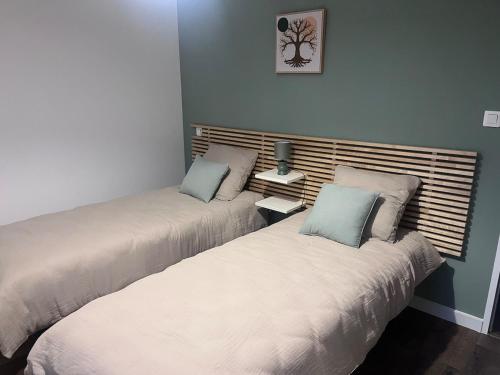 two beds sitting next to each other in a room at Maison de vacances entre forêt et plage in Saint-Jean-de-Monts