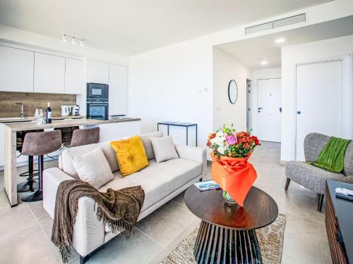 a living room with a couch and a table with flowers on it at Apartment Collection View Free Spa & Padel by Interhome in Torrox Costa