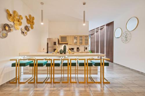 a kitchen with a table with yellow and green chairs at 6 bedroom with Jacuzzi 1 block from LLeras P10 in Medellín